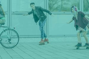 Vier Jugendliche; auf dem Rad, dem Skateboard und Rollschuhen